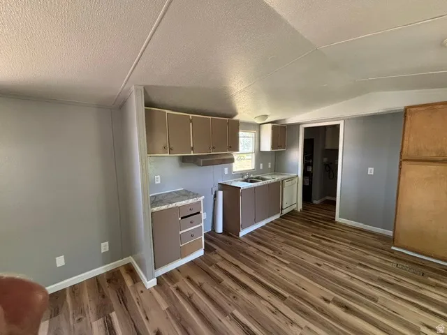 Kitchen featuring wood-finish flooring, light grey walls, and brown cabinetry