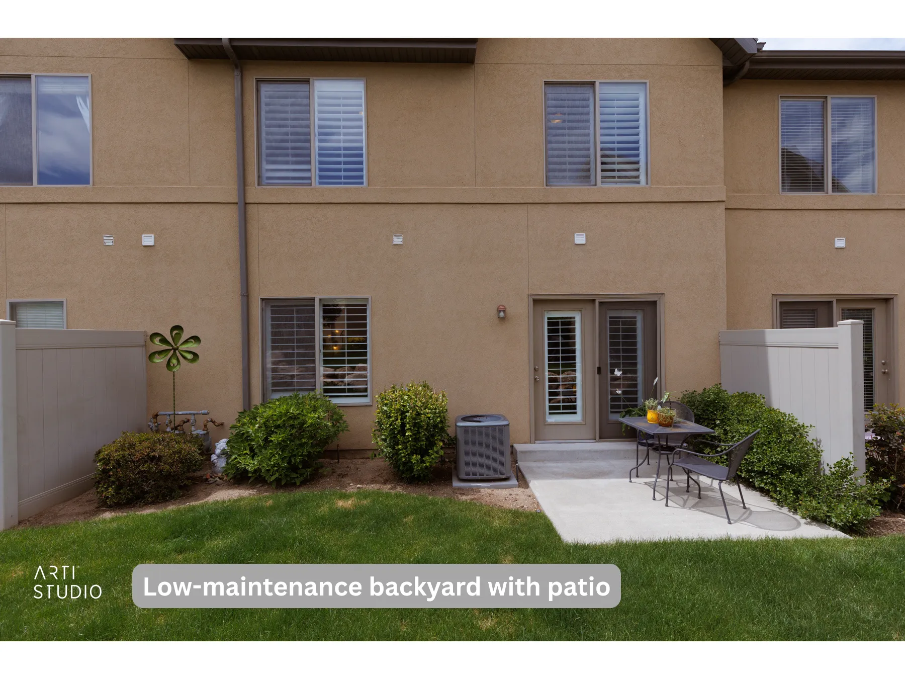 Private backyard with concrete patio, enclosed by a tan vinyl fence