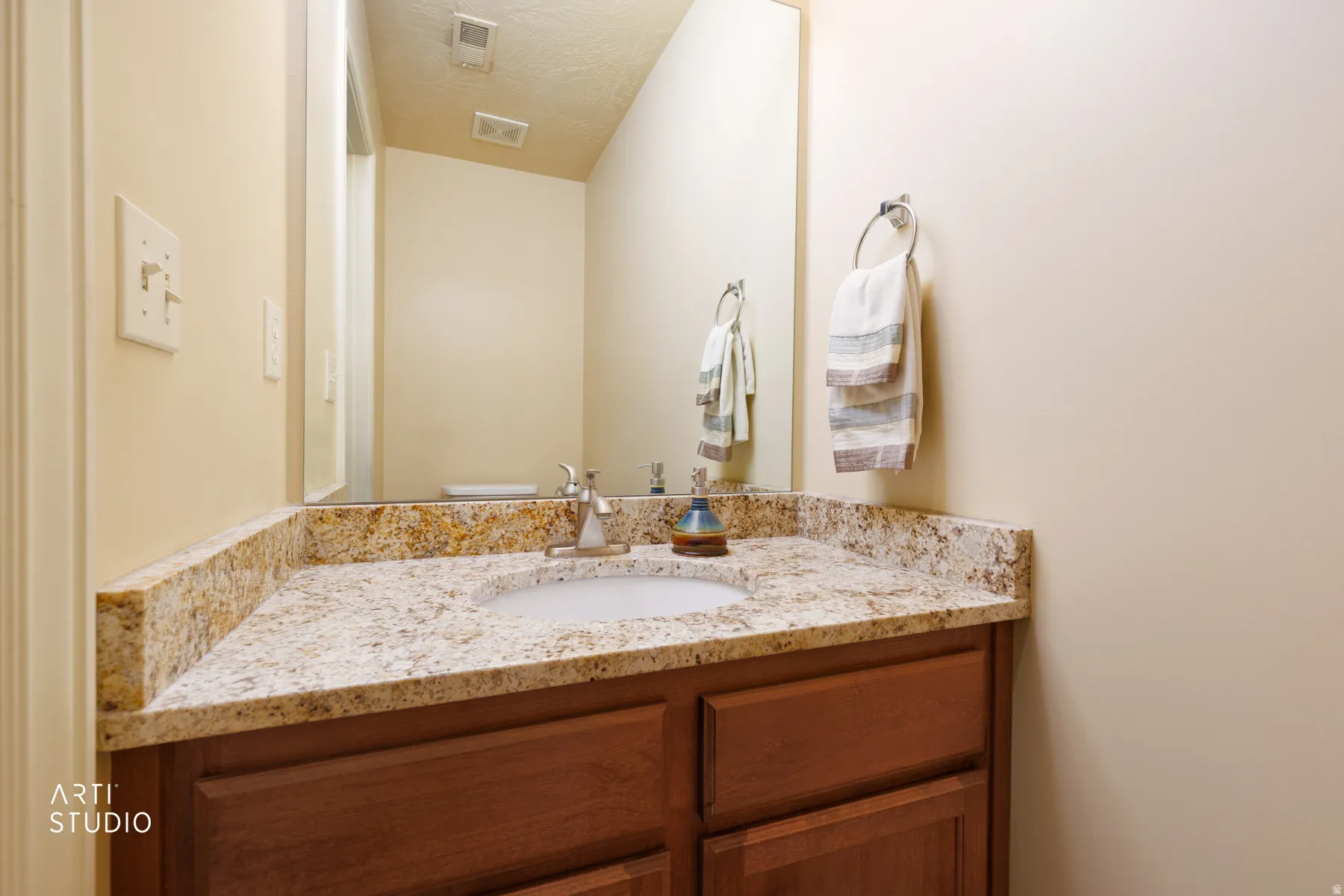 Vanity with a granite countertop, undermount sink, and chrome faucet