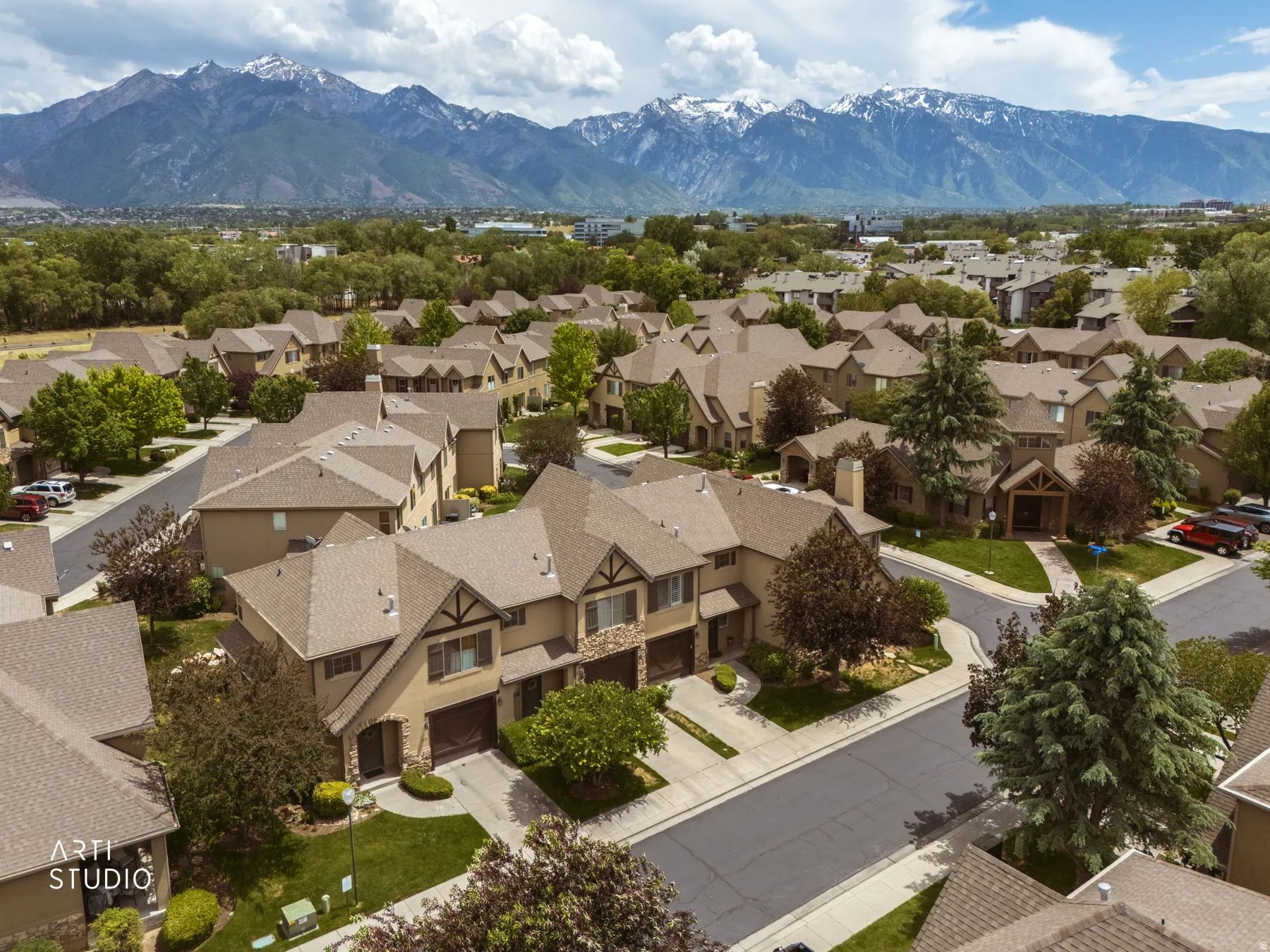 Community of residences featuring pitched roofs and a mountainous backdrop
