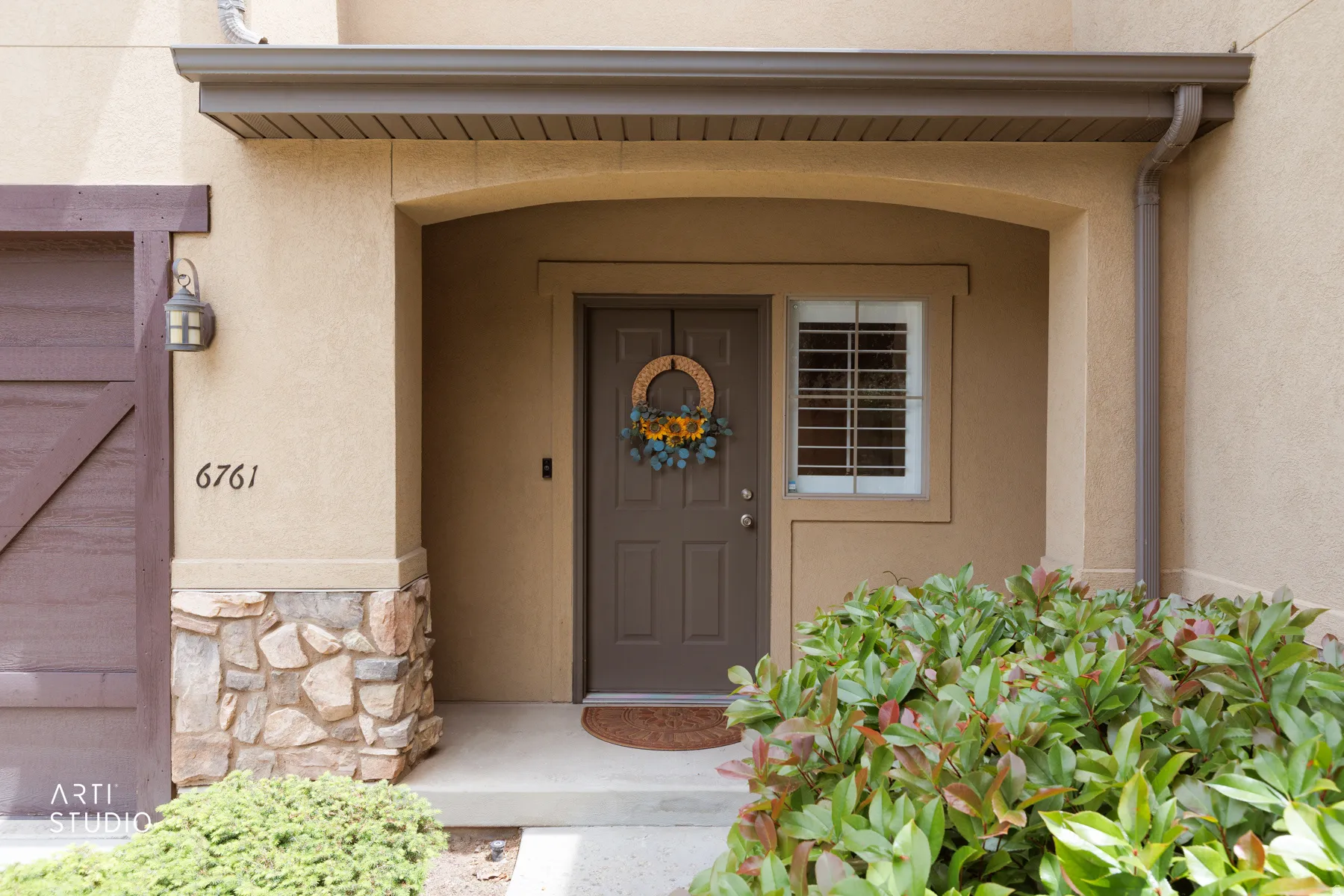 Entryway featuring a covered porch, stone accent siding, and stucco exterior