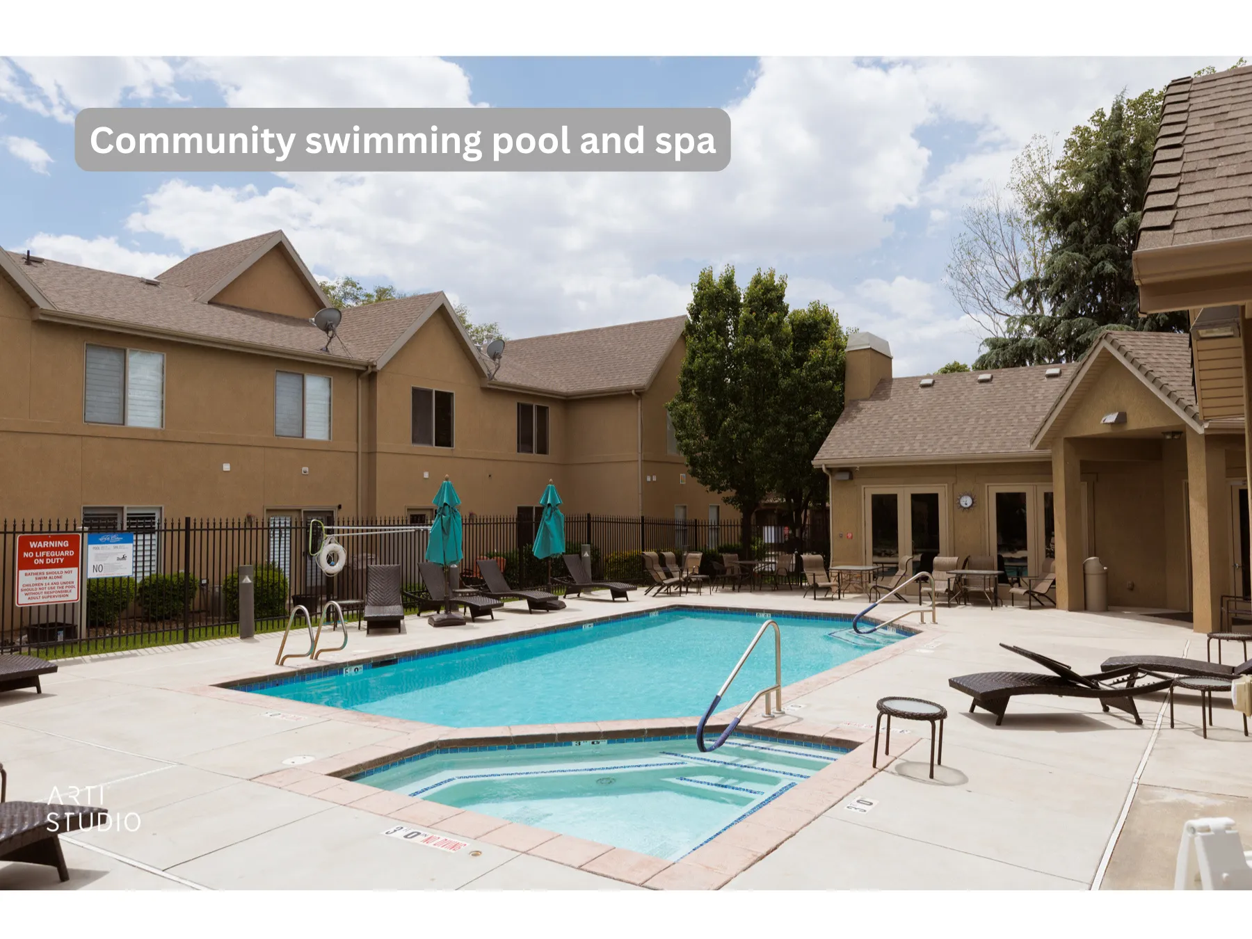 Community swimming pool and integrated spa with surrounding lounge areas, shaded by mature trees