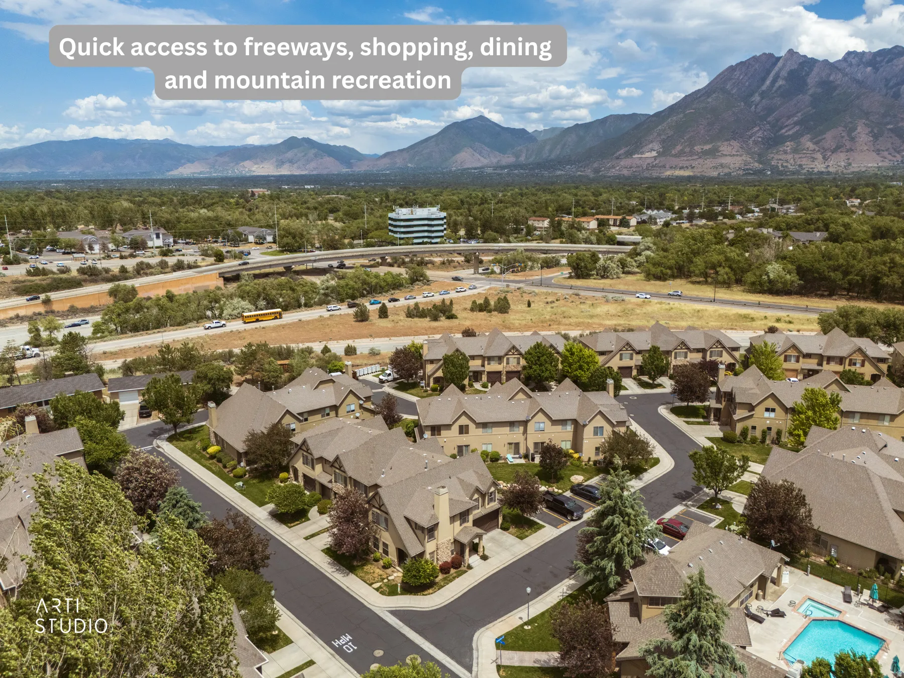 Aerial perspective of a residential community featuring multiple multi-story townhomes with pitched roofs