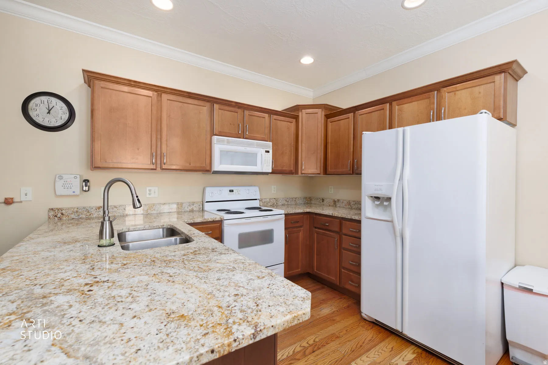 Kitchen featuring wood-finish cabinetry, granite countertops, and wood-finish flooring