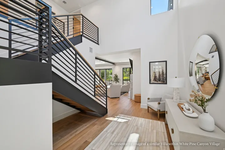 High ceilings, wood-finish flooring, abundant natural light, and modern metal railings