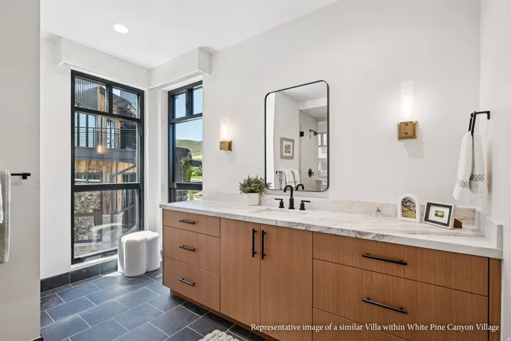 Wood-finish vanity with a light-toned countertop, undermount sink, and matte black fixtures