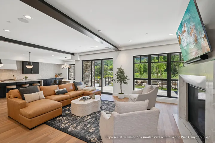 Open-concept living space with wood-finish flooring, a contemporary fireplace, and black-framed windows
