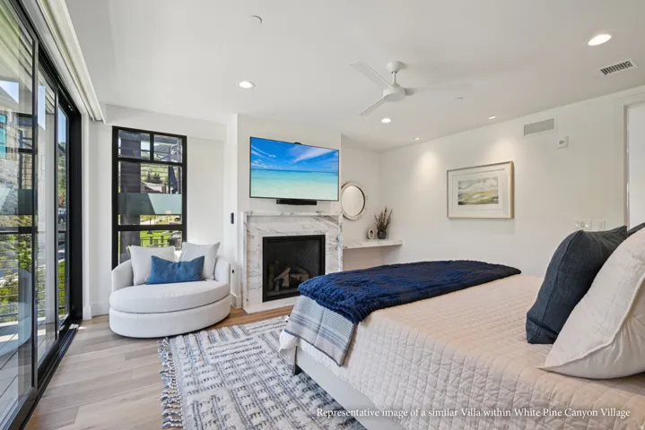 Spacious room with large sliding glass doors, a built-in fireplace with a stone surround, recessed lighting, and light wood-finish flooring