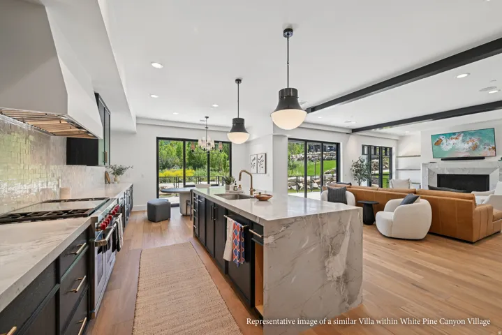 Gourmet kitchen with professional-grade range, full-height tile backsplash, and expansive waterfall island