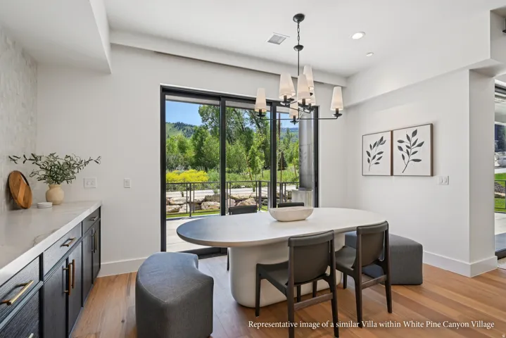 Wood-finish flooring, built-in cabinetry with stone countertop, large sliding glass doors, and a contemporary chandelier