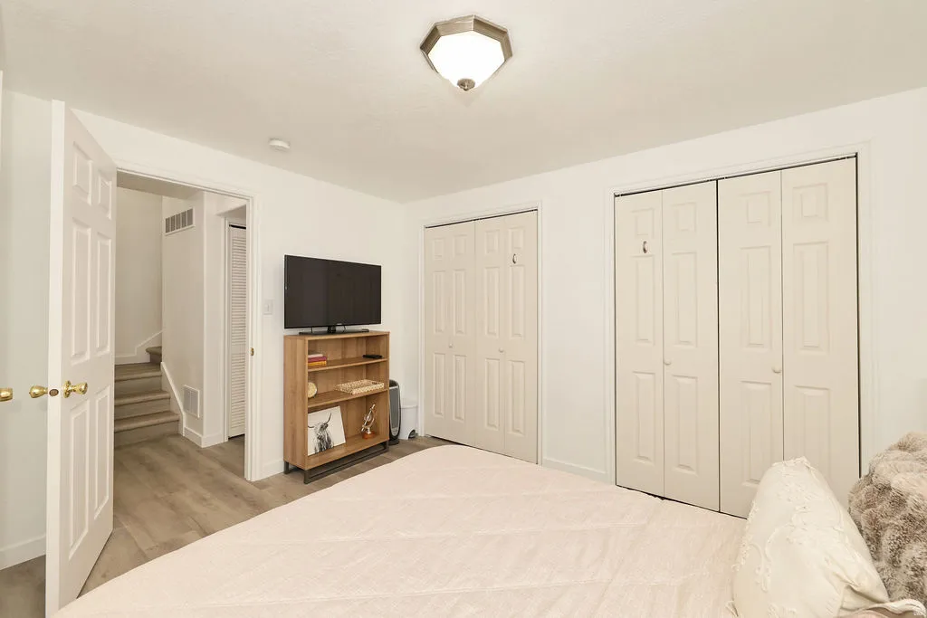 Interior room with wood-finish flooring, white walls, and a semi-flush mount ceiling light