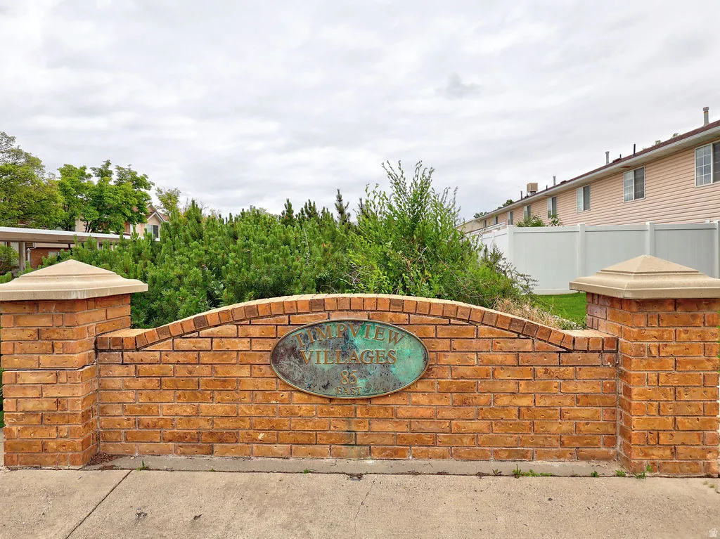 Brick entry monument with stone cap accents and an oval plaque