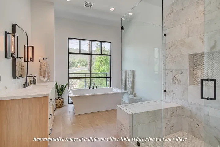 Contemporary bathroom featuring a freestanding soaking tub, expansive window with black framing, wood-finish flooring, a double vanity with stone countertops, and a glass-enclosed shower with a built-in bench