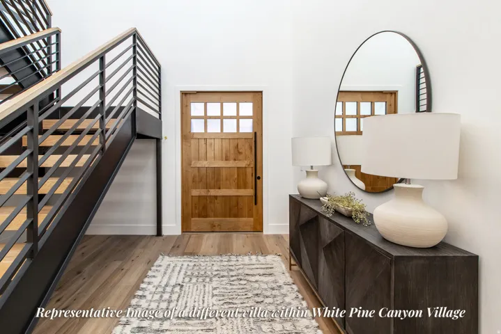 Foyer featuring a natural wood-finish entry door with multiple glass panes, a modern open-riser staircase with black metal railings and wood-finish treads, and wood-finish flooring throughout