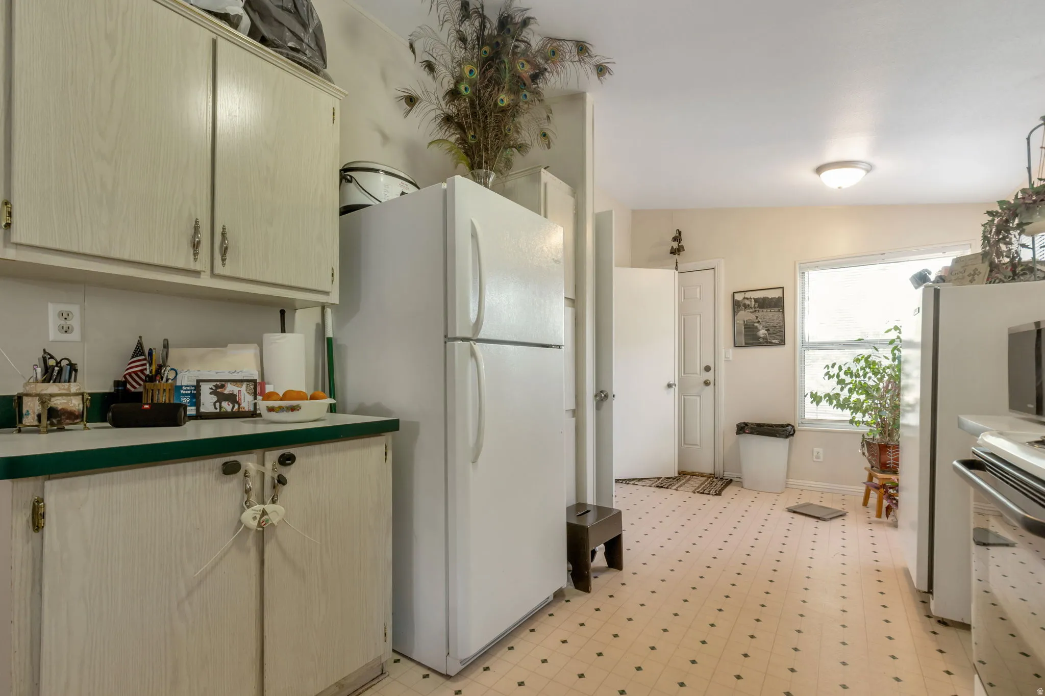 Kitchen space featuring a patterned vinyl floor, light-toned cabinetry, and a ceiling-mounted light fixture