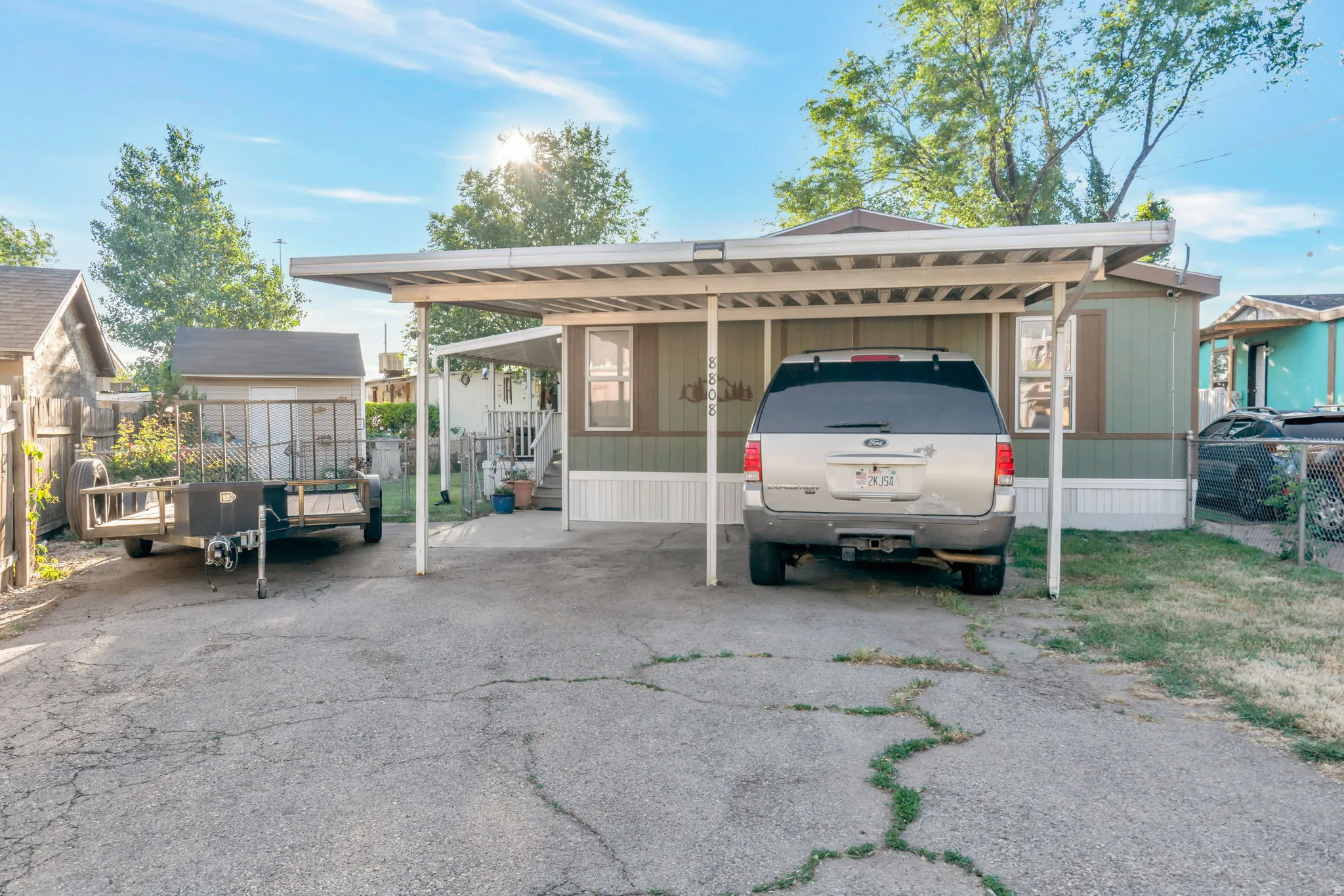 Exterior featuring a carport, a secondary shed, and a fenced perimeter