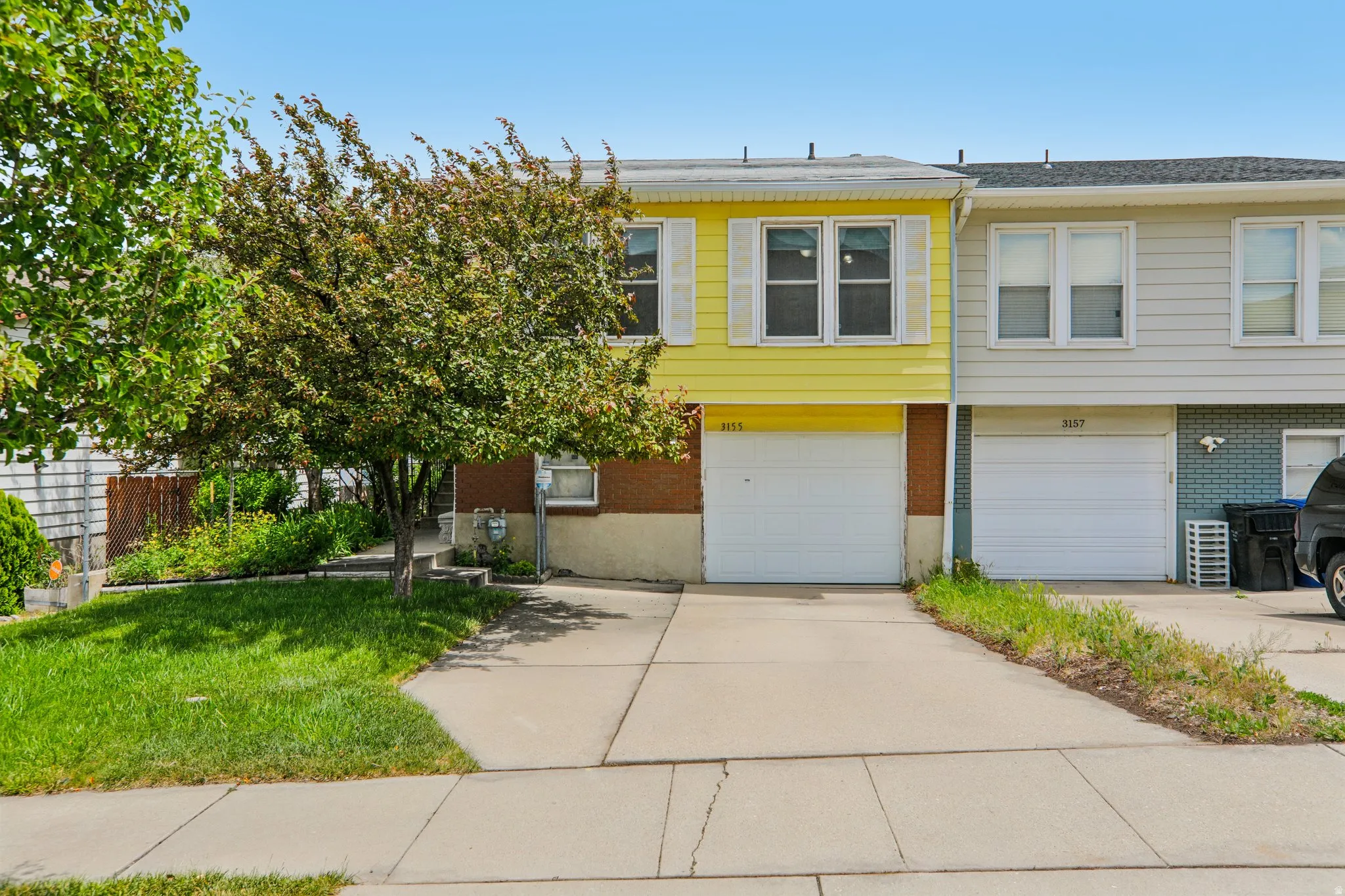 Yellow siding facade with white window trim and shutters