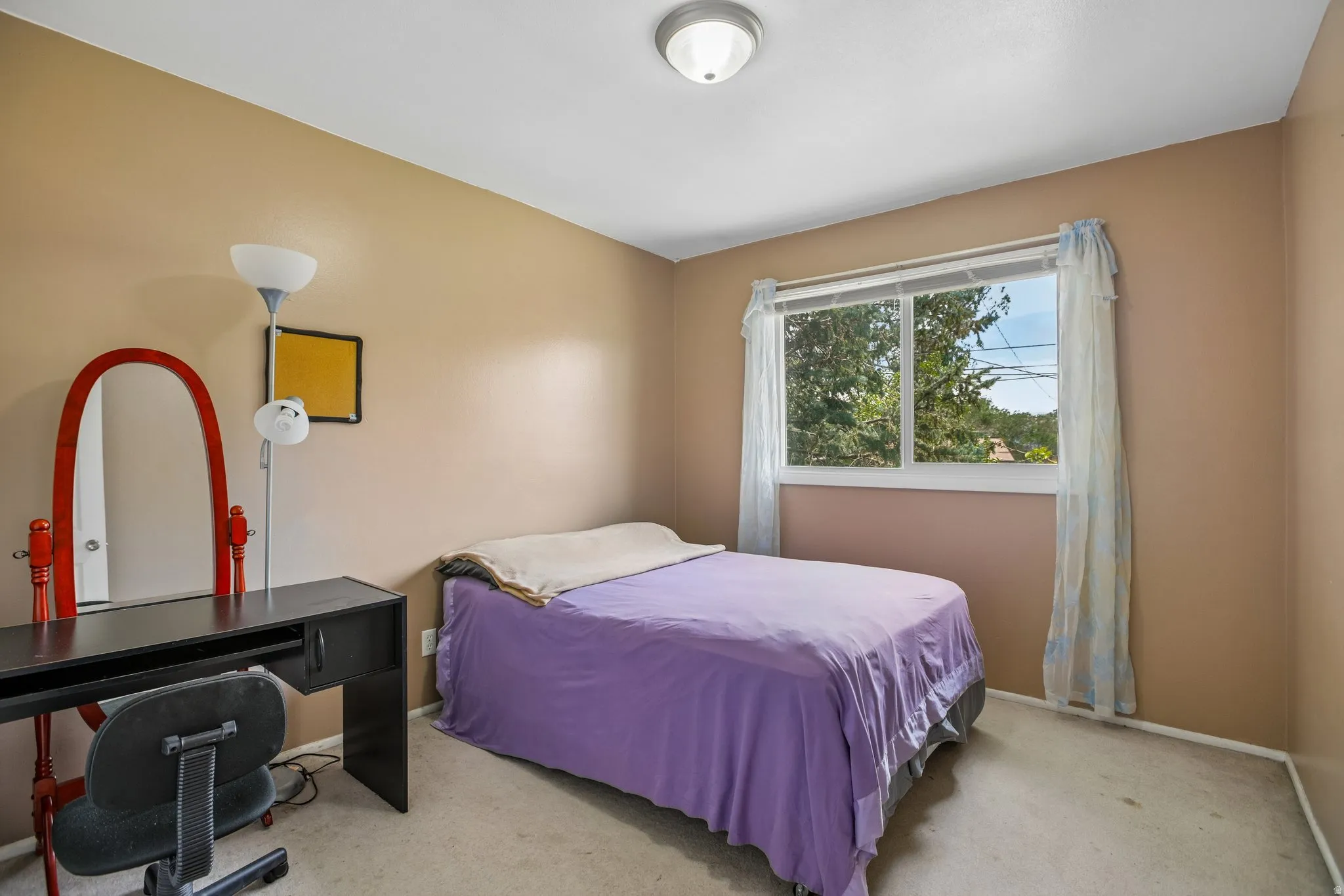Bedroom featuring carpet flooring, a single window with vertical blinds, and a flush-mount ceiling light fixture