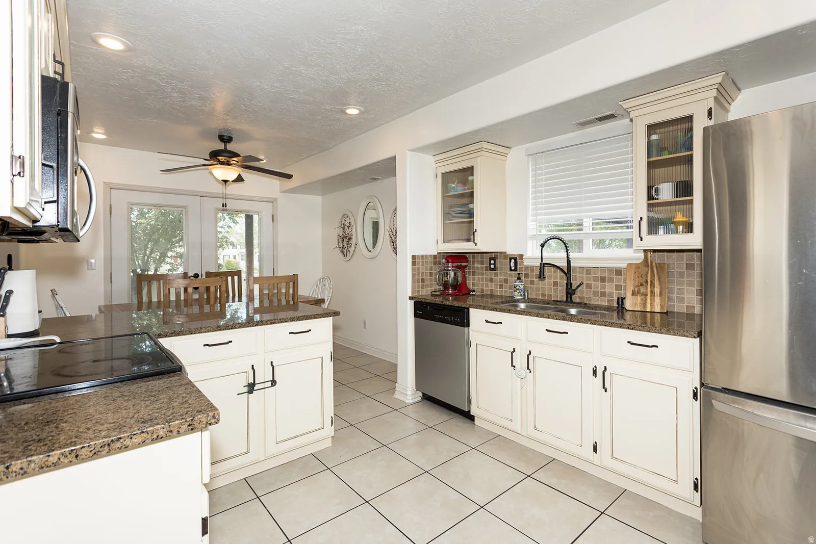 Kitchen featuring recessed lighting, a ceiling fan, light-toned cabinetry, and granite-finish countertops