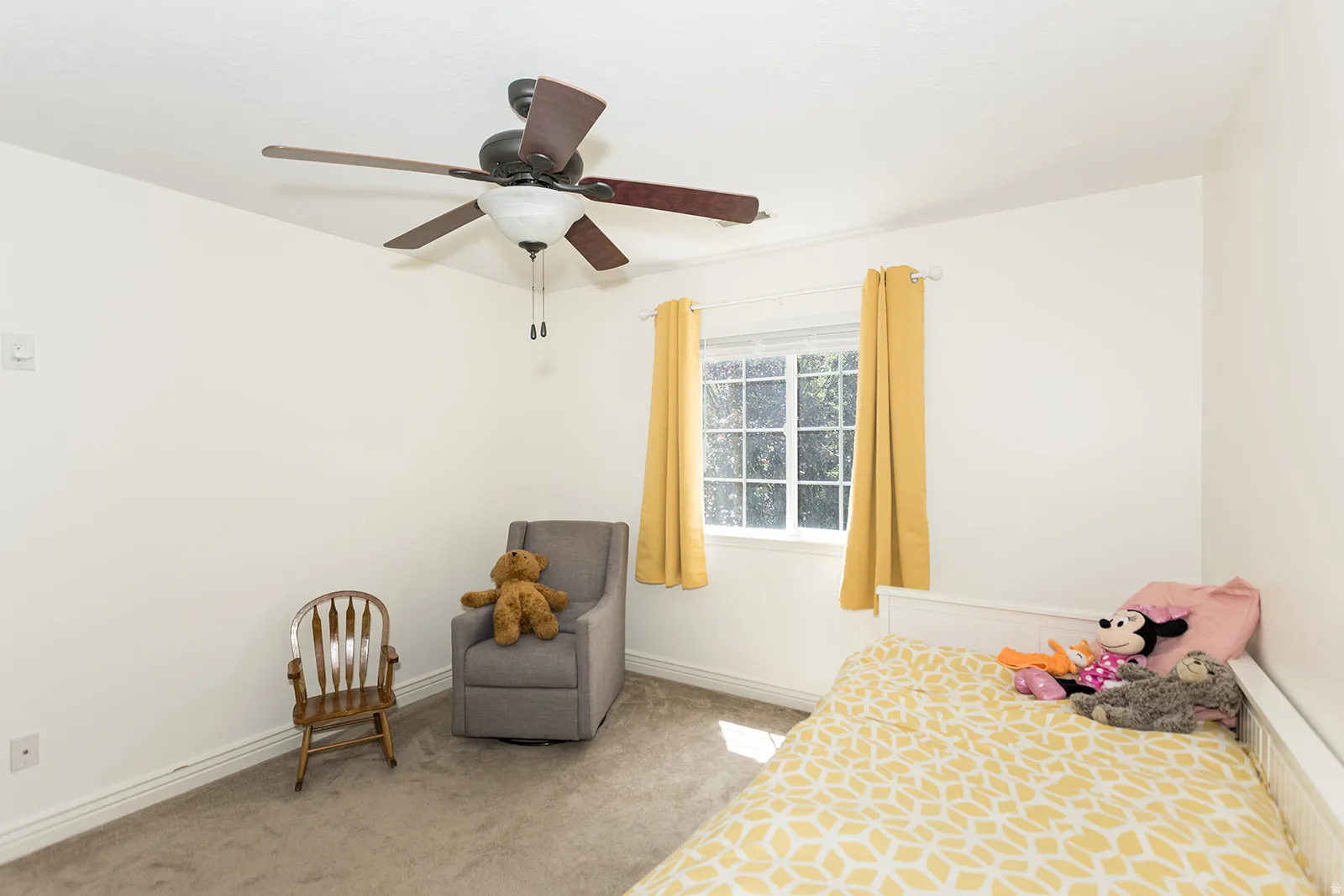 Bedroom featuring a ceiling fan with integrated lighting, a window with exterior views, white baseboards, and neutral wall paint