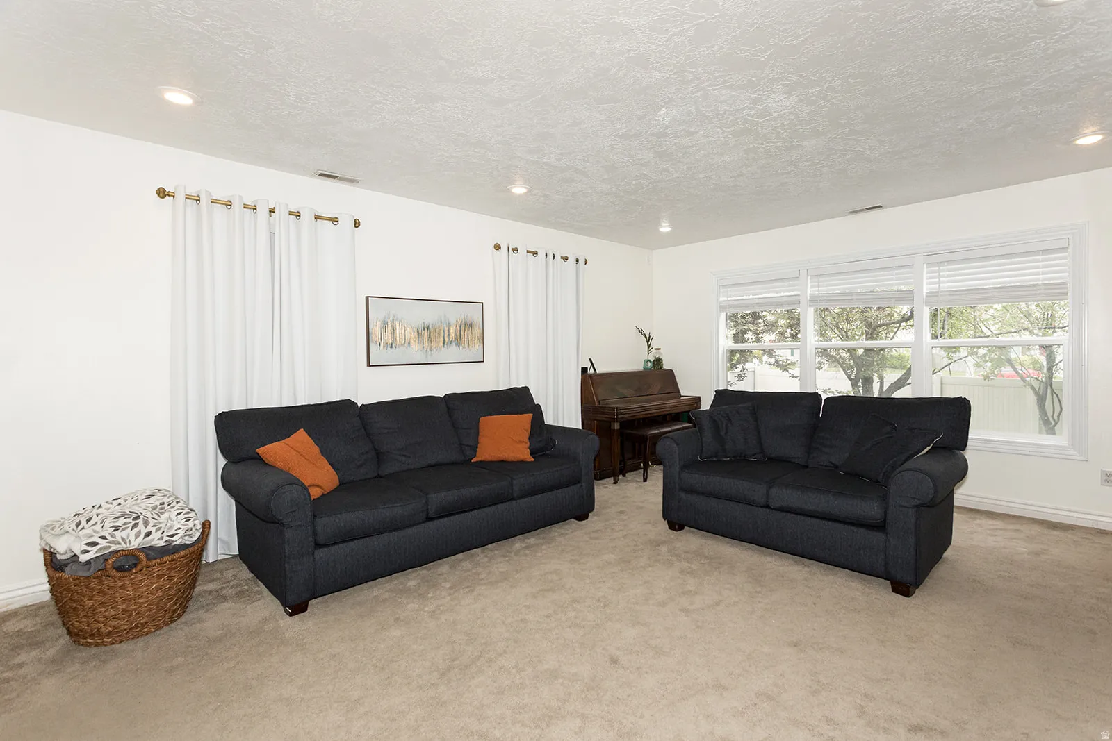 Spacious interior room featuring carpeted flooring, light-toned walls, and recessed lighting