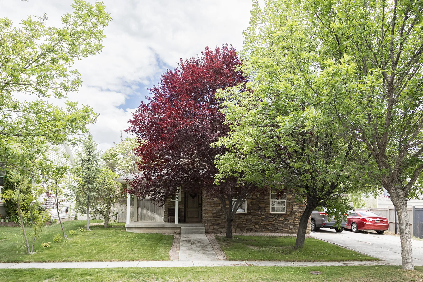 Stone veneer exterior with a covered front porch and mature landscaping