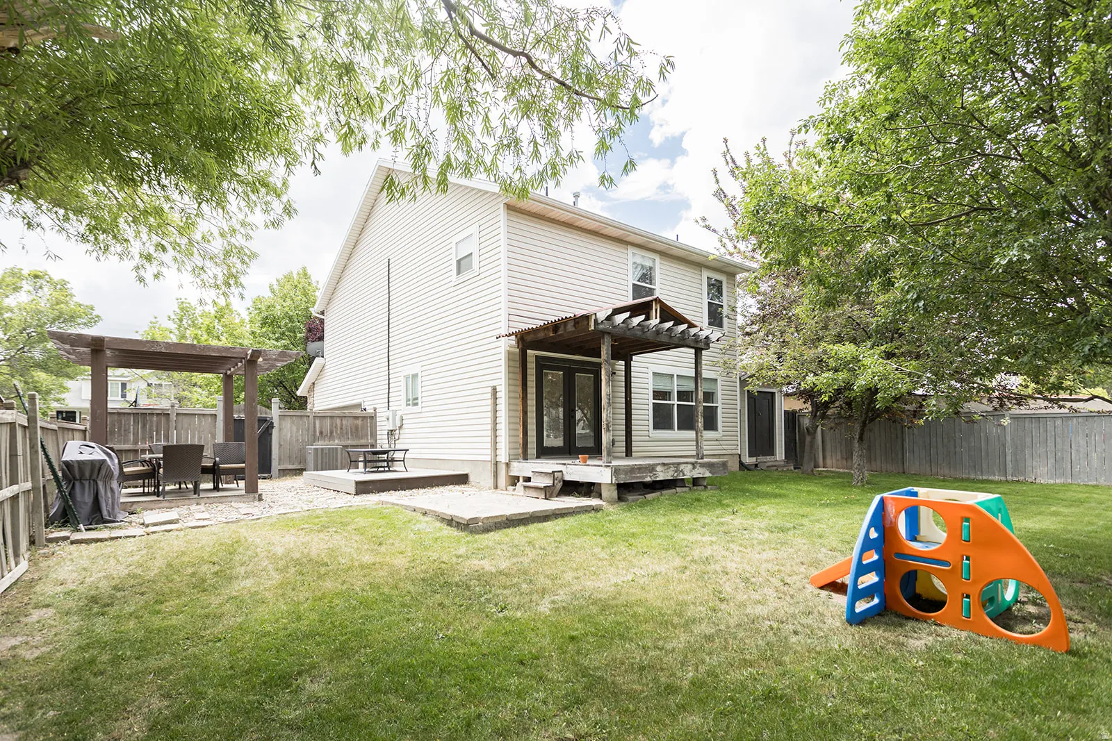 Expansive green lawn with a privacy fence