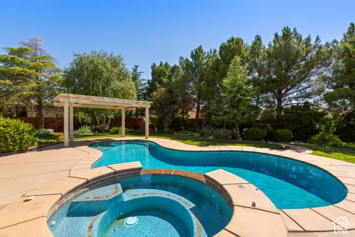 Freeform swimming pool with integrated spa and surrounding concrete decking