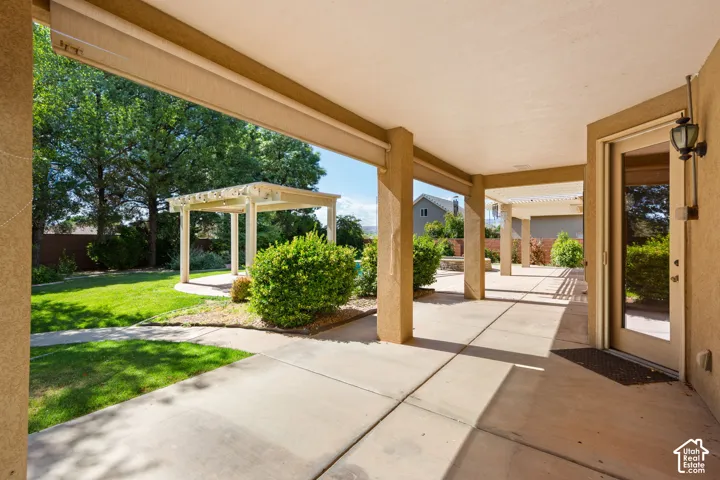 Expansive covered patio with concrete flooring, supported by stucco columns