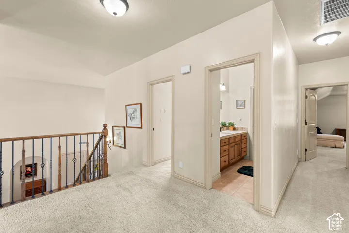 Open landing area featuring light-toned carpeting and flush-mount ceiling lighting