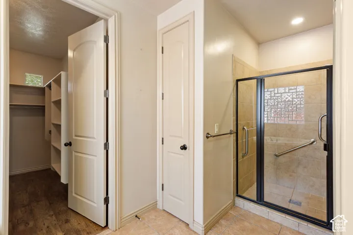 Walk-in shower with clear glass enclosure and decorative tile accent
