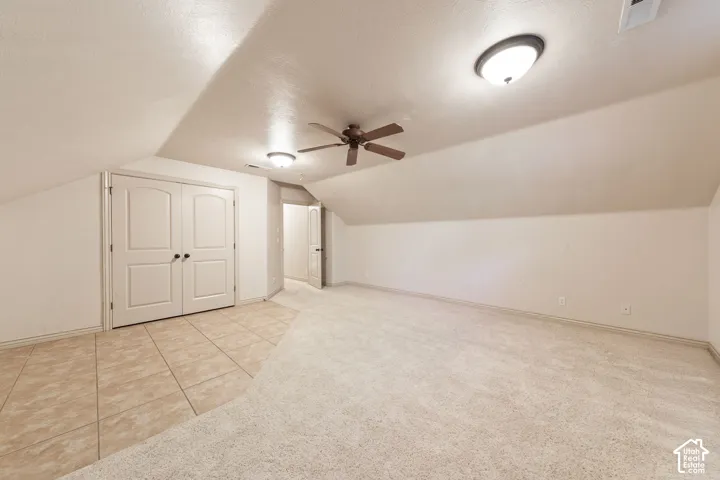 Vaulted ceiling with a ceiling fan and flush-mount lighting