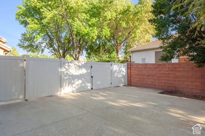 Concrete paved surface with a privacy fence, double gate, and a block wall