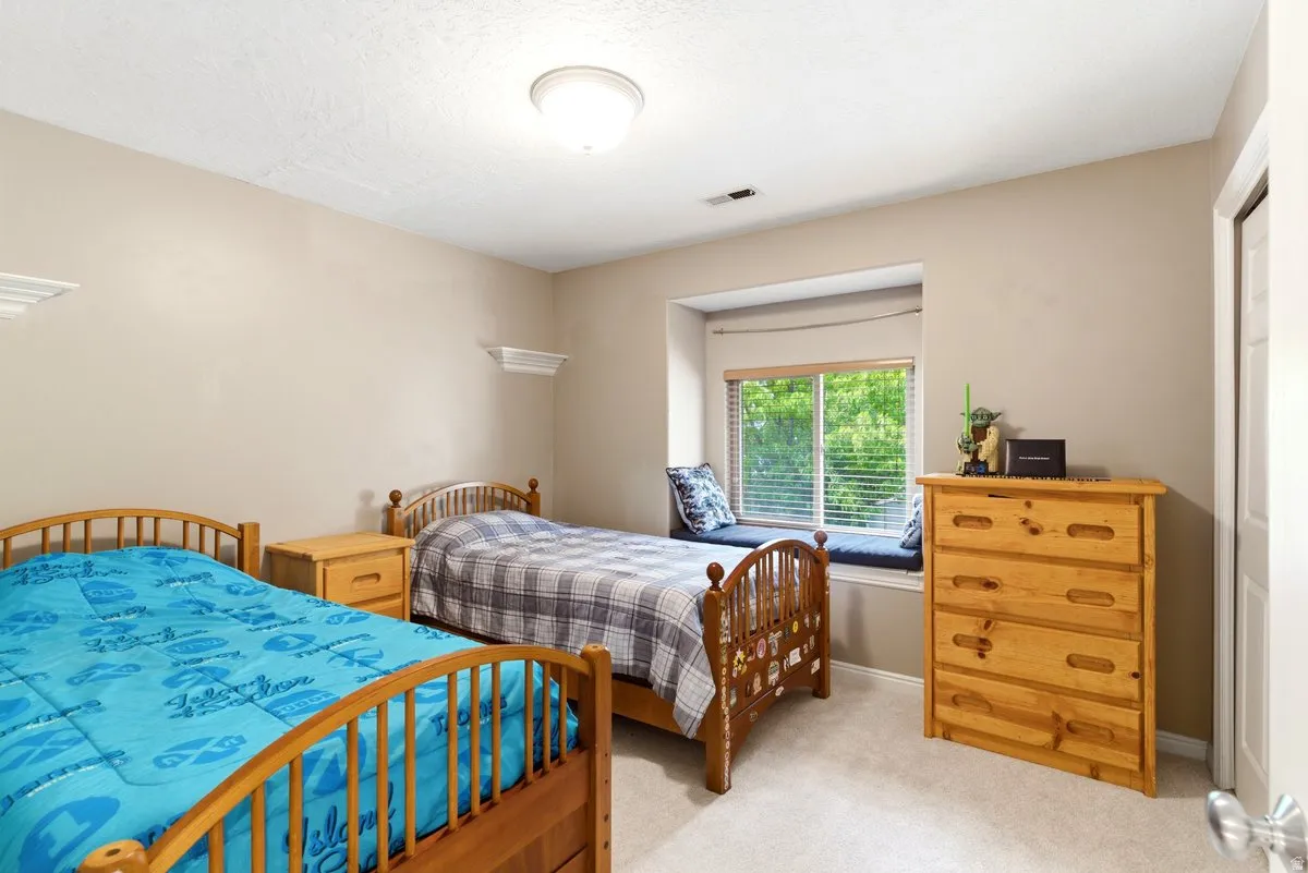 Bedroom featuring a window seat with cushions, neutral carpet, and a flush-mount ceiling light