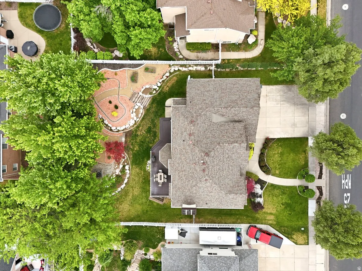 Expansive property showcasing a manicured lawn, mature trees, a driveway, and a paved patio area