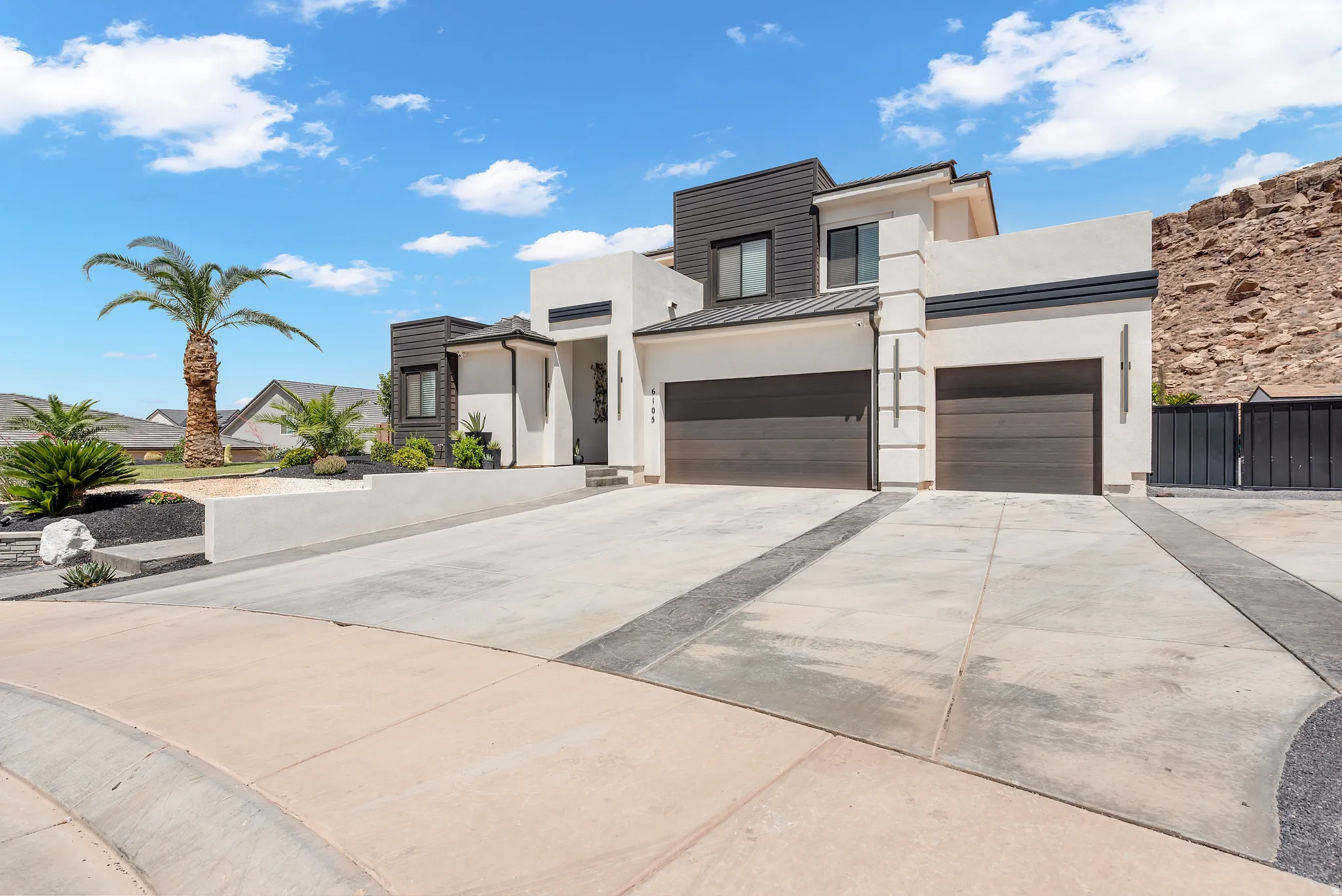 Contemporary stucco and wood-look exterior with dual garage doors