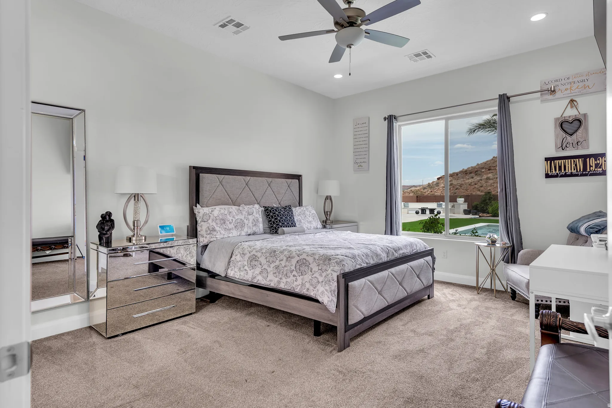 Carpeted bedroom featuring a large window, vaulted ceiling, and recessed lighting