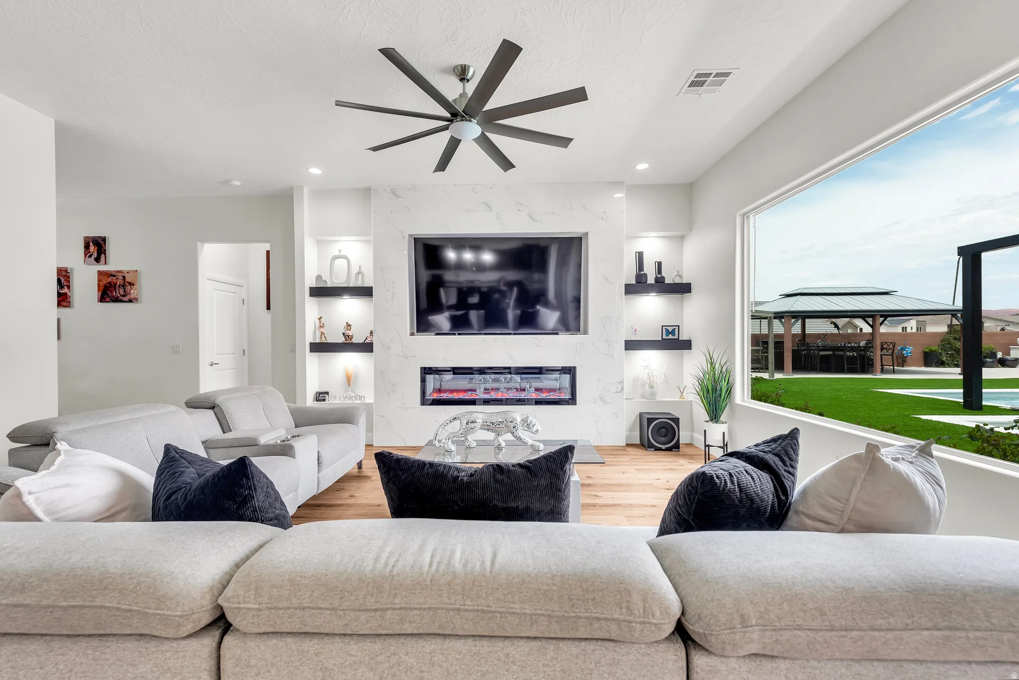 Living area featuring wood-finish flooring and a contemporary ceiling fan