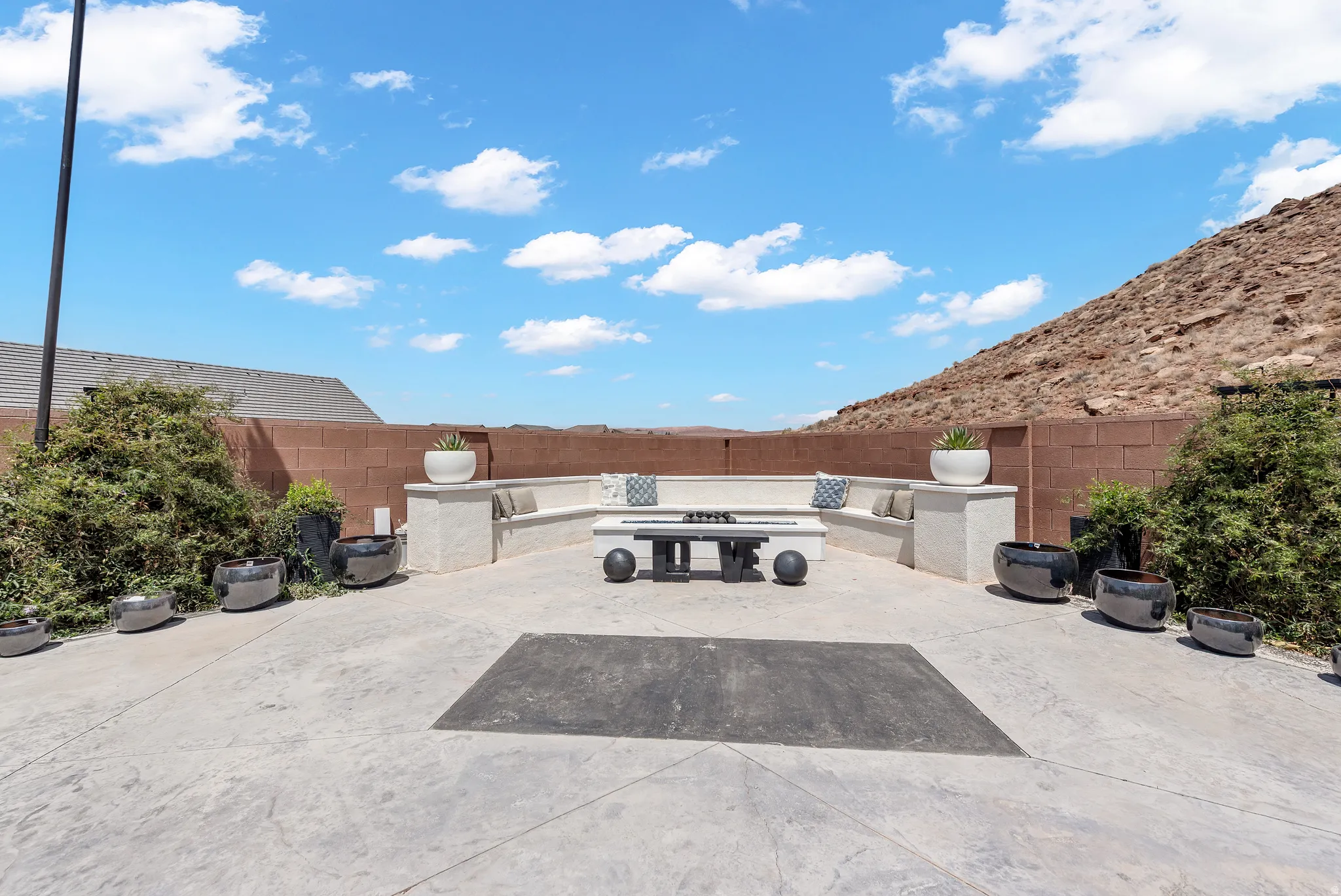Expansive hardscaped patio featuring a built-in bench seating area
