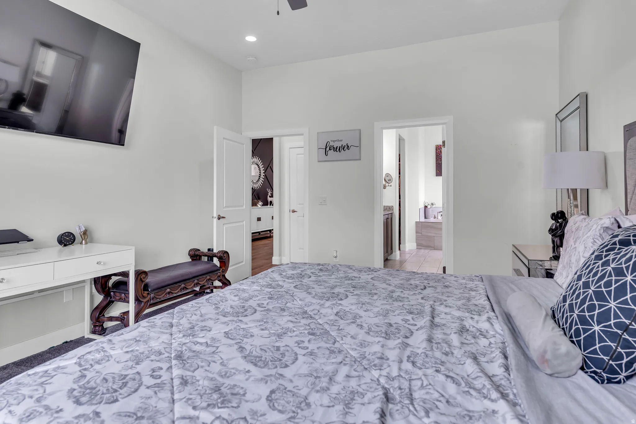 Bedroom with light-toned walls and a ceiling fan