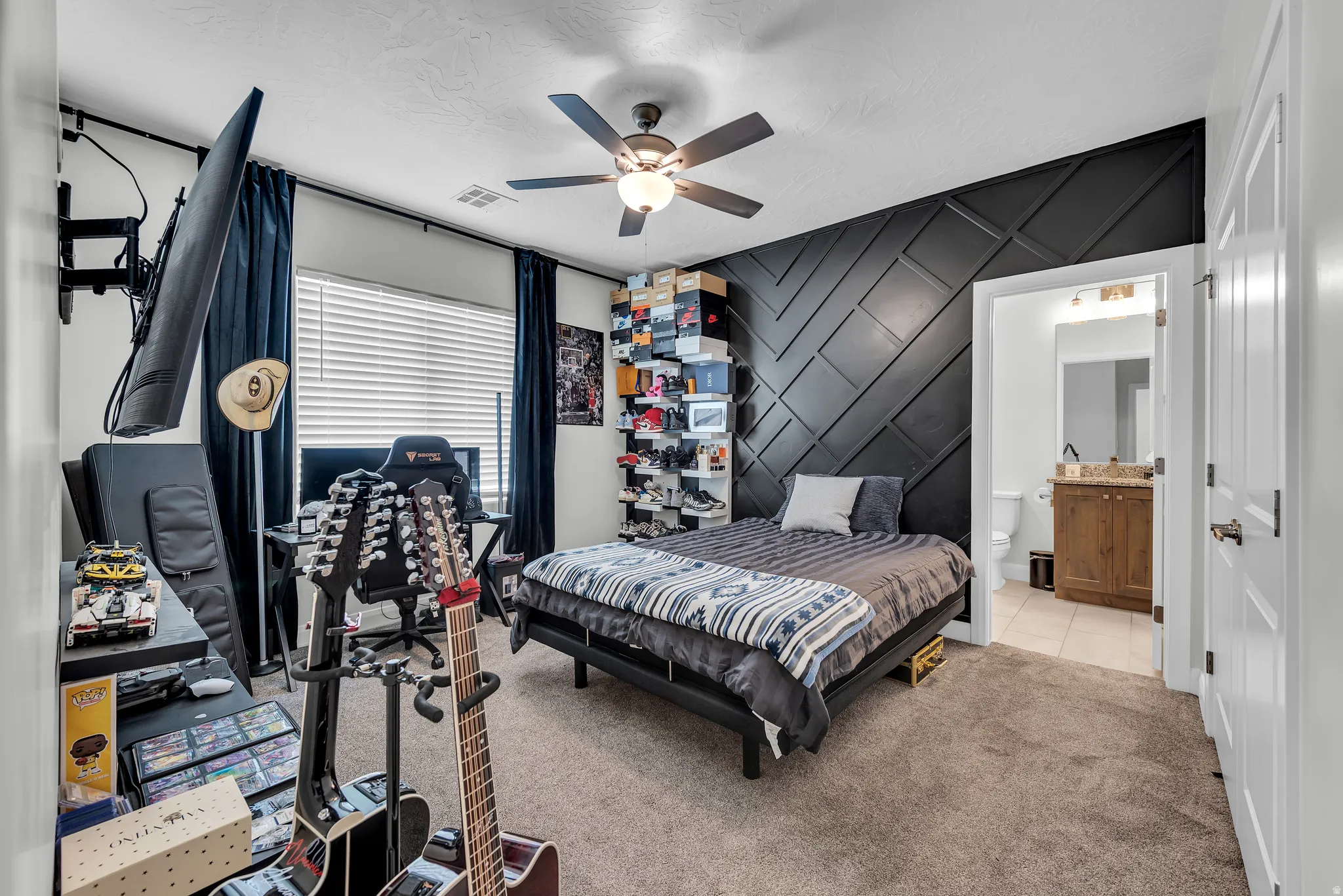 Bedroom featuring a striking black accent wall with geometric paneling