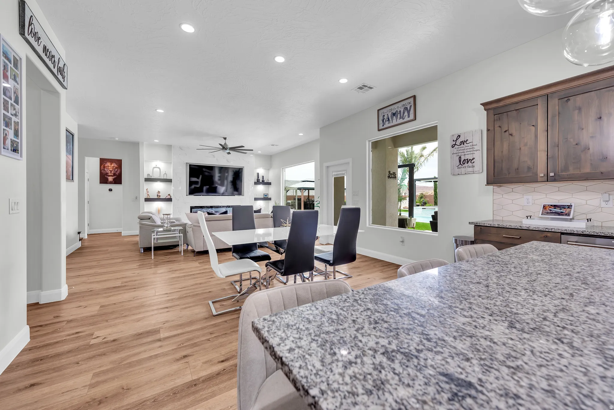 Open-concept living space featuring wood-finish flooring, recessed lighting, and a contemporary ceiling fan