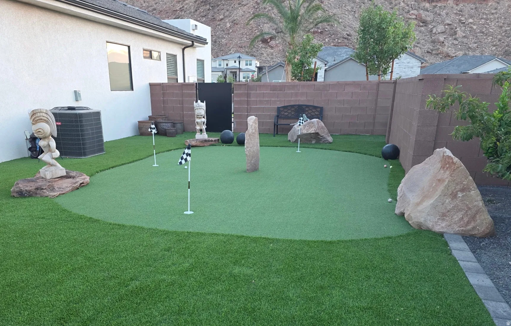 Backyard putting green surrounded by artificial turf