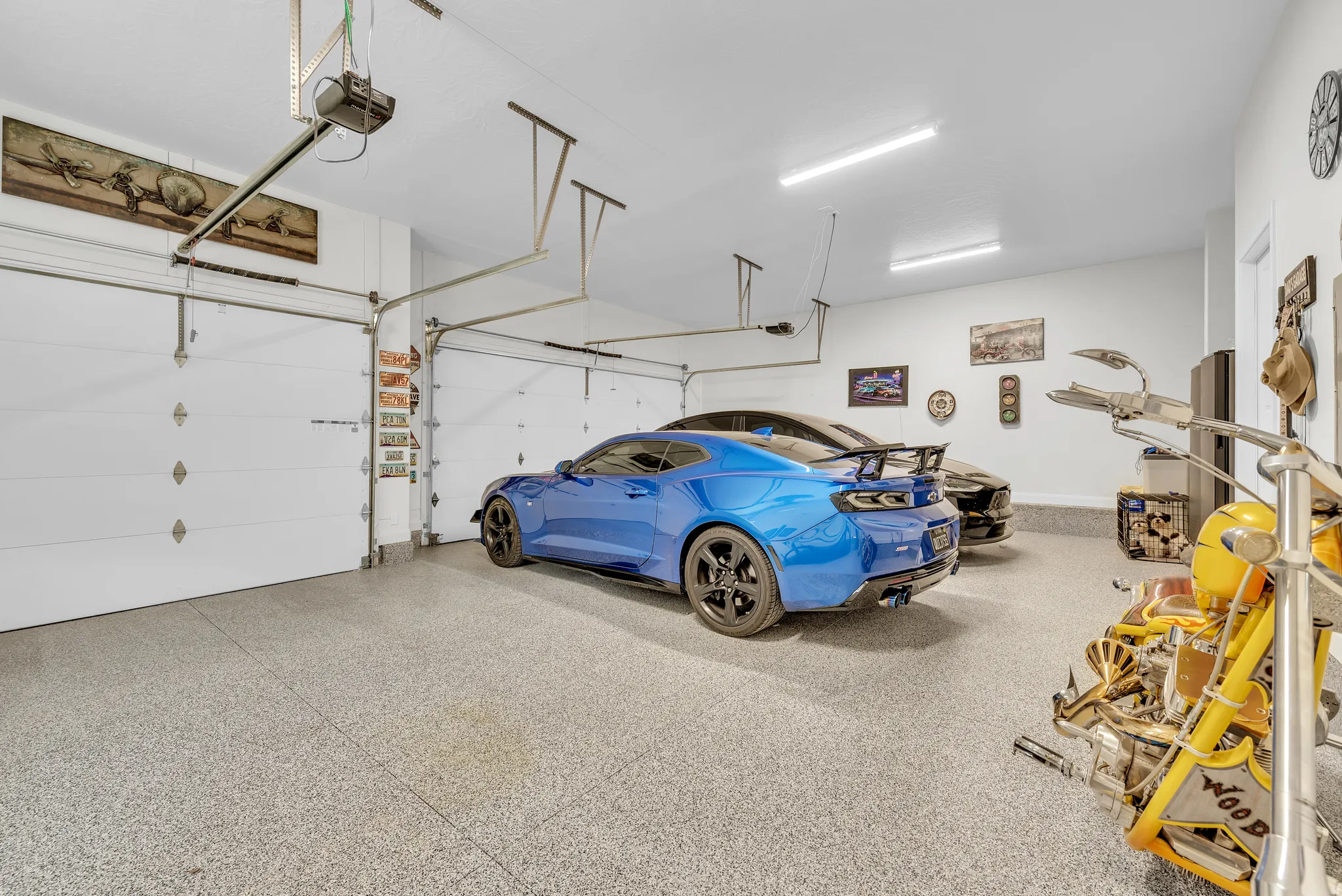 Spacious garage featuring a durable epoxy floor, white walls, and bright overhead lighting