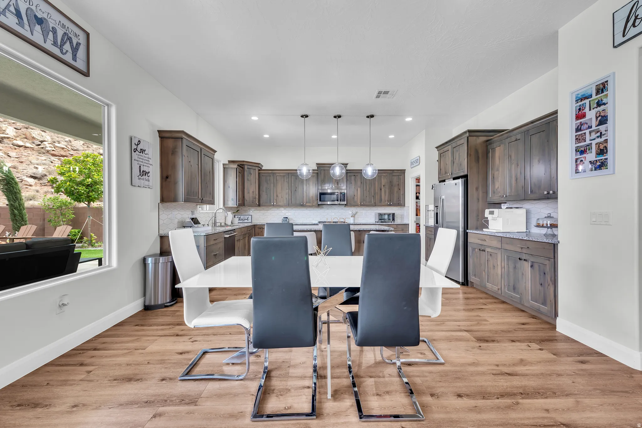 Open-concept kitchen and dining area featuring wood-finish flooring and recessed lighting