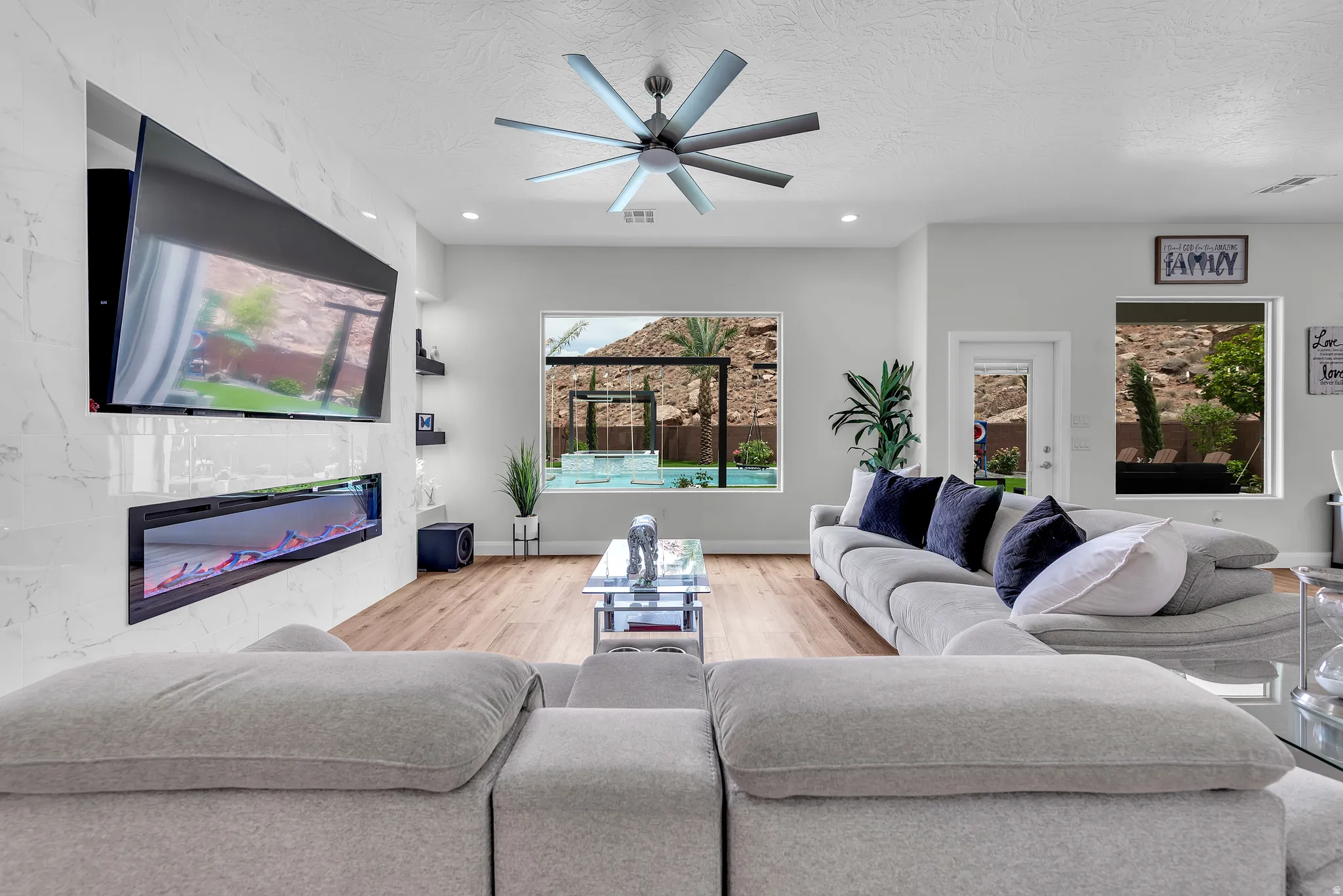 Living area featuring wood-finish flooring, recessed lighting, and a contemporary ceiling fan