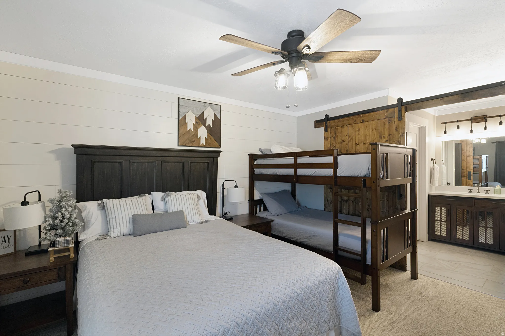 Neutral-toned bedroom featuring shiplap accent walls, a dark wood headboard, and bunk beds