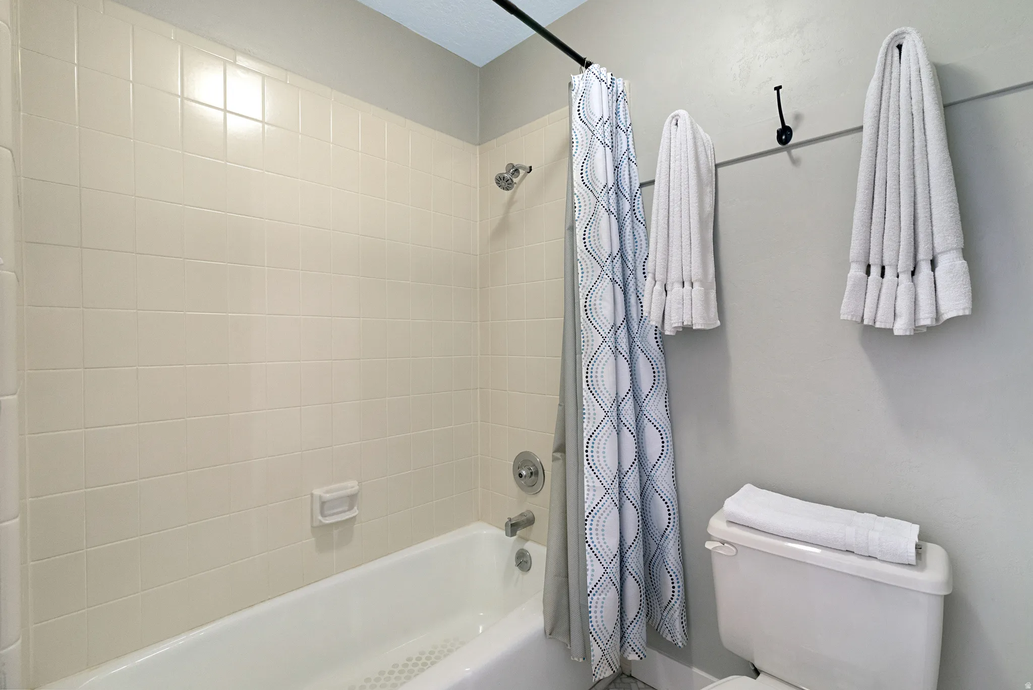Bathroom with white tiled shower surround and tub