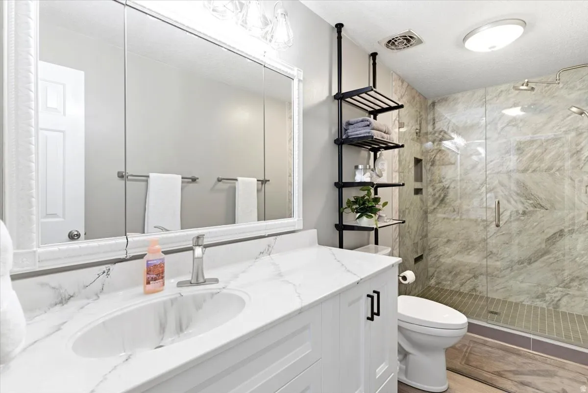 Bathroom featuring a white vanity with an undermount sink, a white countertop with grey veining, and a large mirrored medicine cabinet