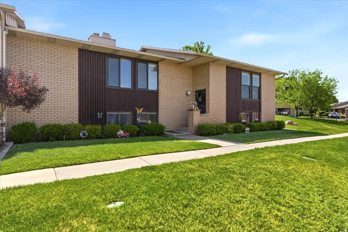 Brick exterior featuring dark vertical siding accents and a covered entryway